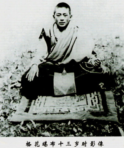 A black-and-white photograph of thirteen-year-old Hor shul Khenpo Gelek Palsang Rinpoche seated outdoors on a mat in monastic robes.