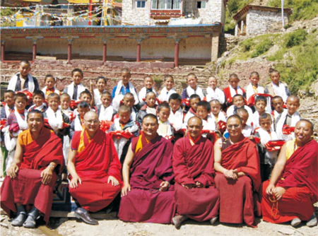Hor shul Khenpo Gelek Palsang Rinpoche poses with students and monastics of a branch school in Master Mencuo's hometown before a monastery.