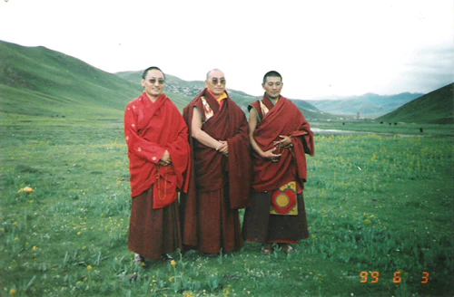 Hor shul Khenpo Gelek Palsang Rinpoche, Tulku Dongga, and Shiqu Sexu Chiba Rinpoche stand together on grassland in monastic robes.