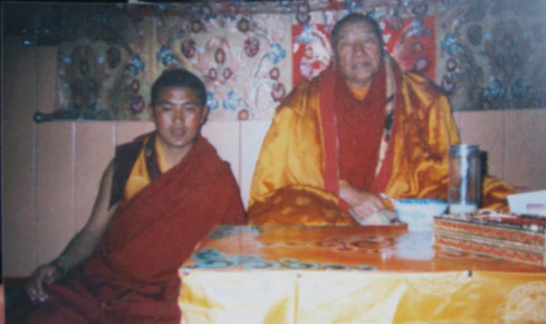 Hor shul Khenpo Gelek Palsang Rinpoche and the Fourth Dodrupchen Rinpoche sit together in monastic robes at an indoor table.